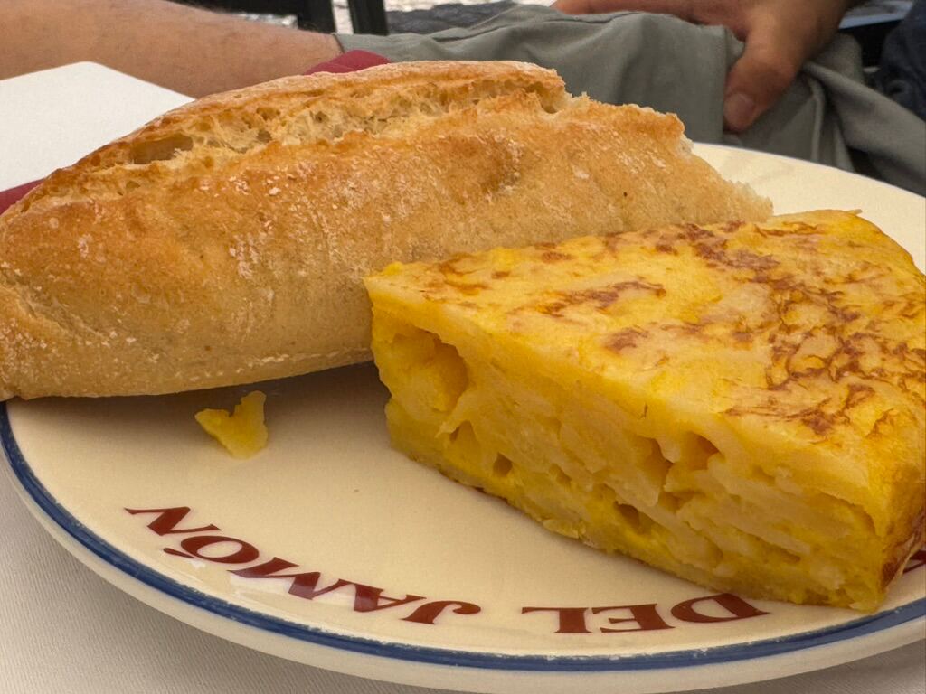 Ein St&uuml;ck Tortilla espa&ntilde;ola mit Baguette auf einem Teller