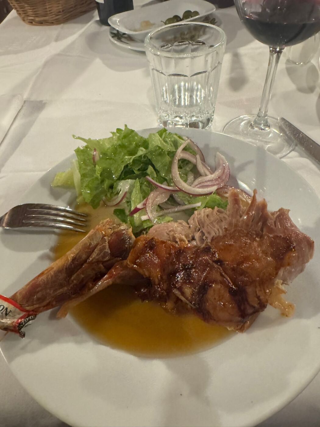 Teller mit Lammbraten, Sauce und Salat mit roten Zwiebeln